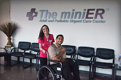 a nurse helping a man in a wheel chair at the miniER